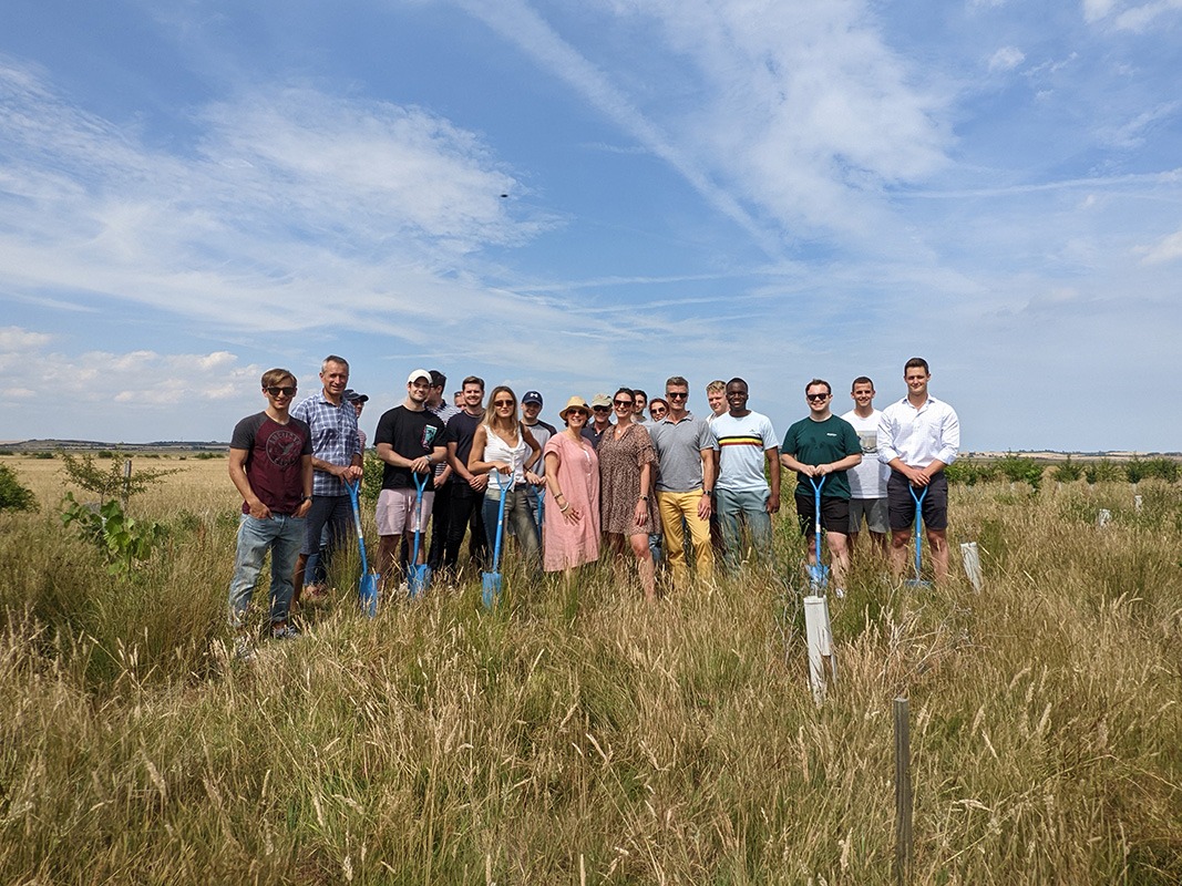 Silverpeak team posed together in a field with some holding shovels